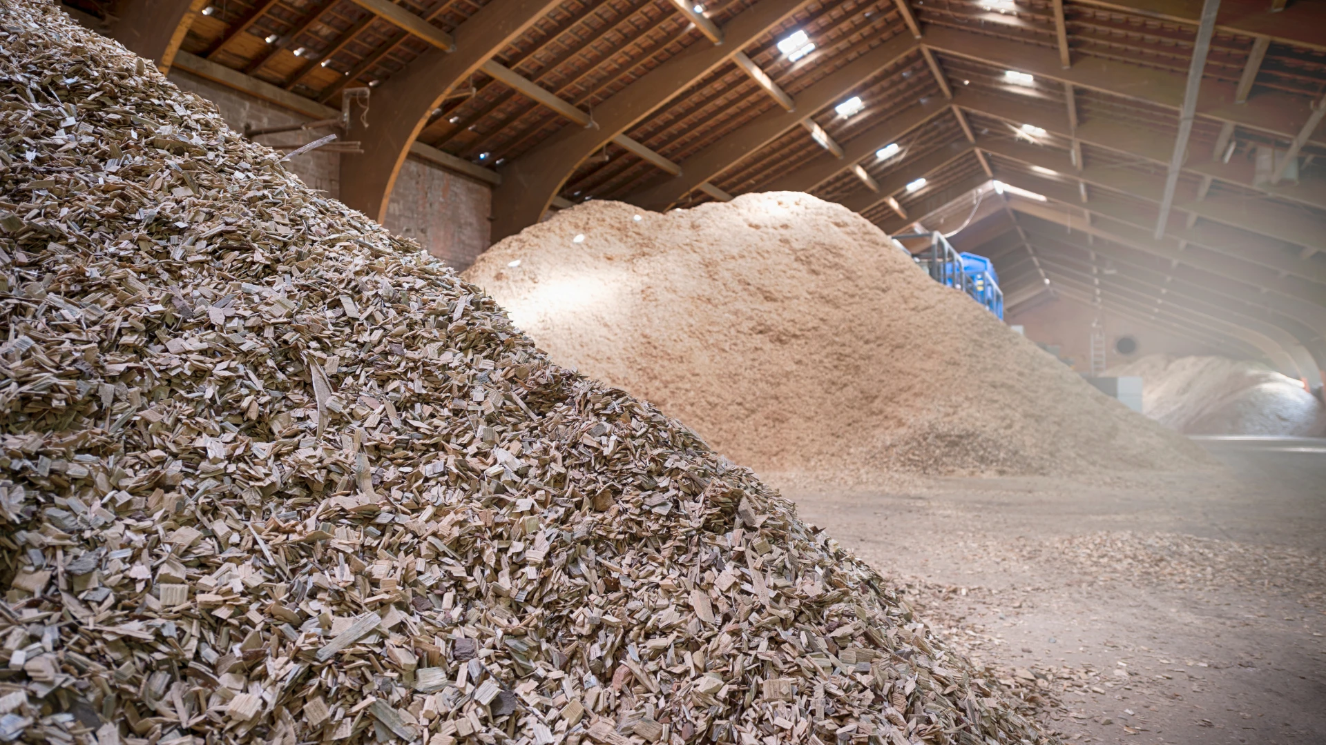 Biomass supplier in Poland – a warehouse with large piles of wood chips and sawdust intended for renewable energy production.