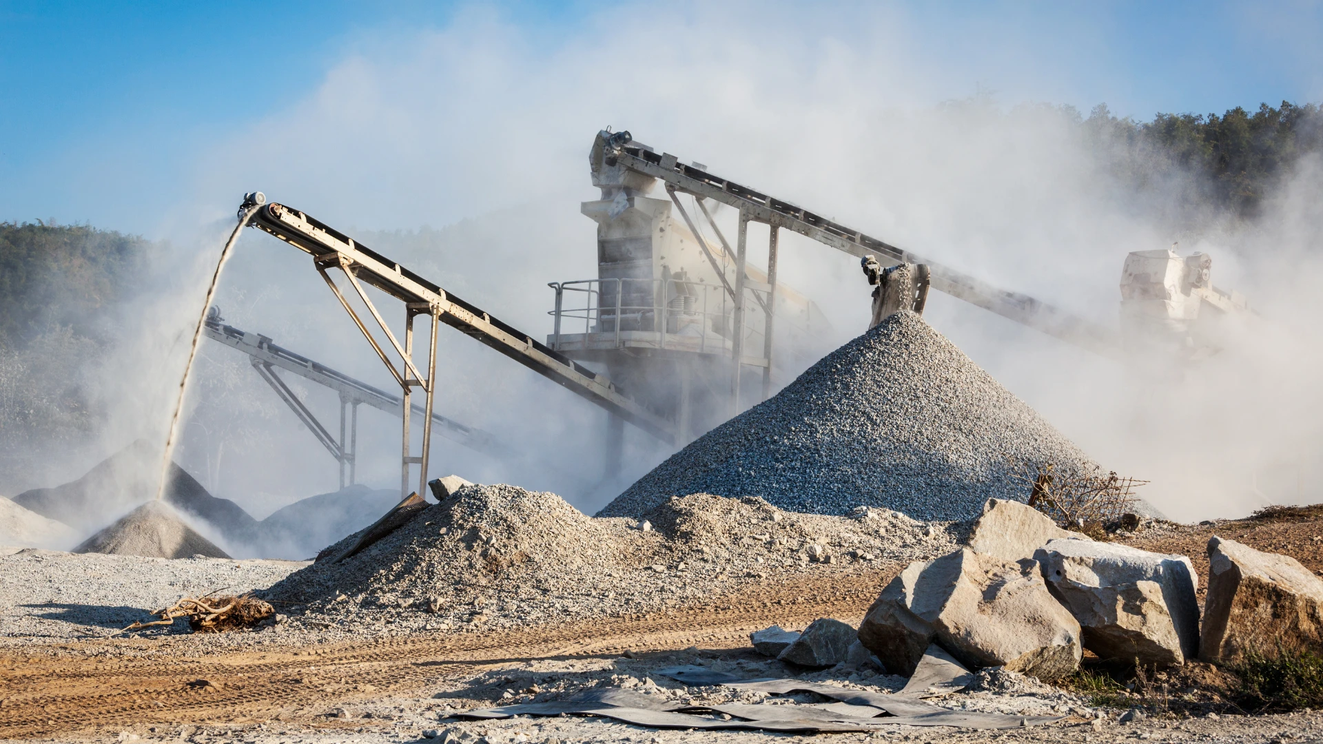 Industrial rock supplier – a crushing and sorting plant for mineral raw materials with visible conveyor belts and aggregate piles.
