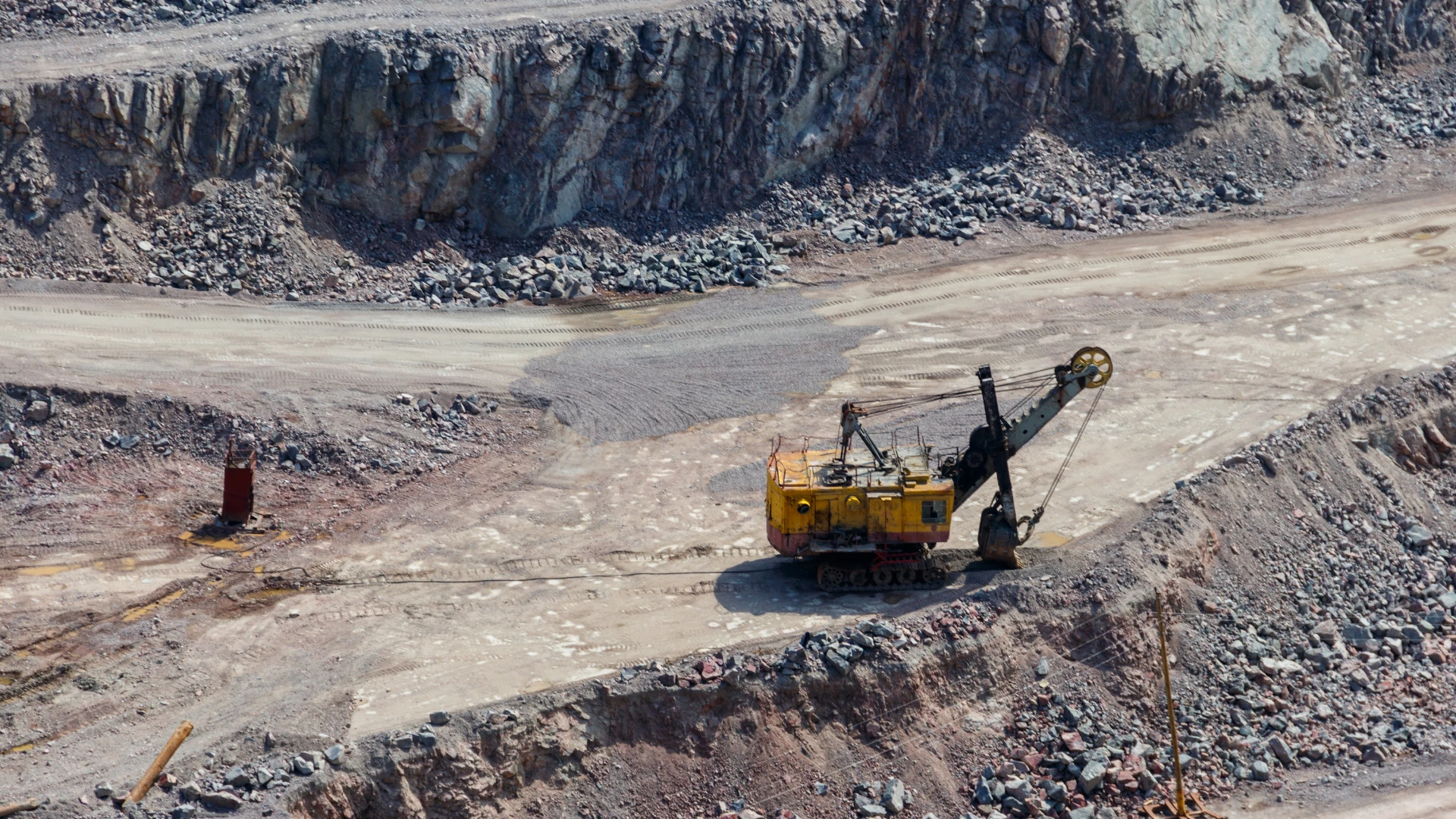 Dostawca surowców mineralnych dla przemysłu – kopalnia odkrywkowa z maszyną górniczą wydobywającą minerały skalne.