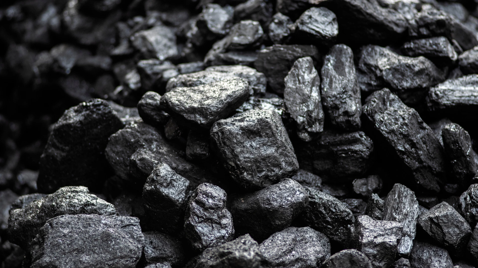 Dark, glossy lumps of high-quality PCI coal arranged in a dense layer, shown in close-up to highlight the structure and uniformity of the raw material – PCI Coal Supplier.