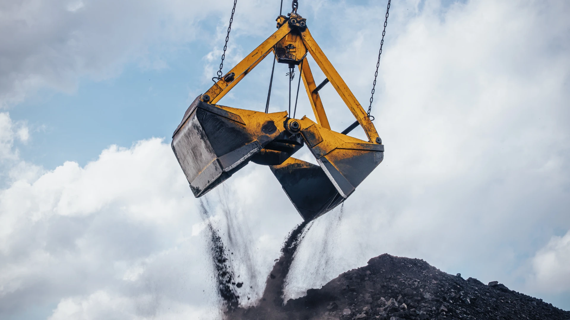 Coal supplier in Silesia – a yellow excavator transferring coal, symbol of the mining industry and energy resource distribution in the region.