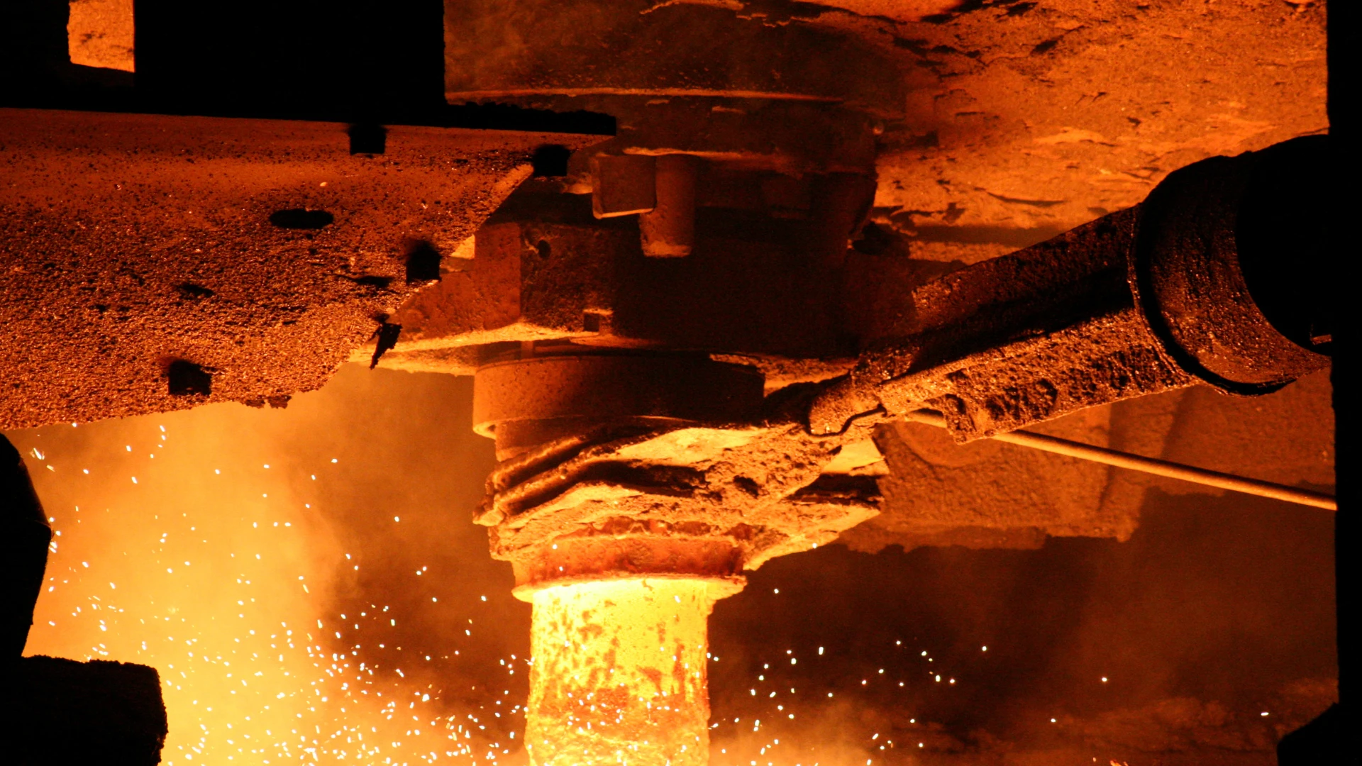 Metallurgical coke wholesale – a glowing stream of metal in a furnace, intense sparks and high temperatures where coke plays a key reducing and energy role in steel production.