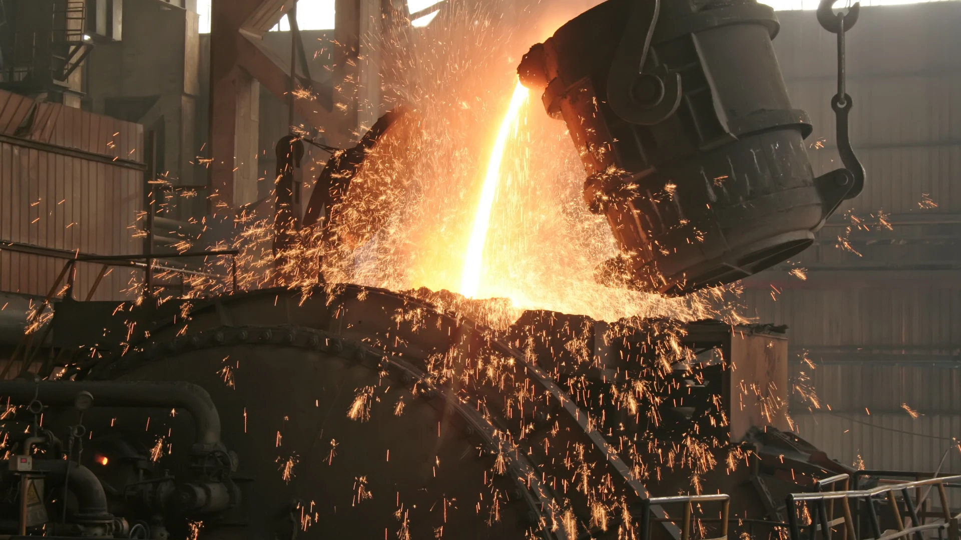 Metallurgical coke wholesale – pouring molten metal into a furnace, intense alloy stream and sparks, where coke is a key energy and reducing raw material in steel production.