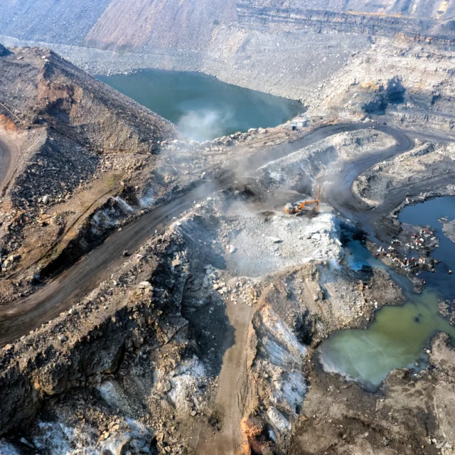 Coal tar in open pit – dark, dense pools of tarry coke residues between rock dumps