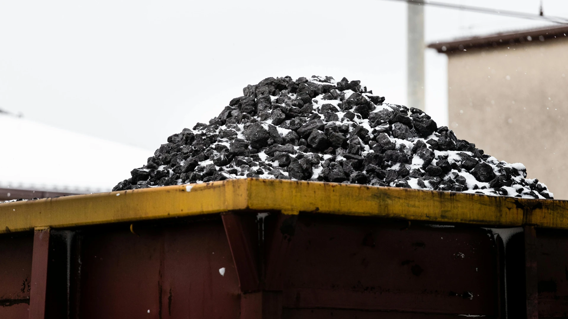 Dostawca smoły węglowej – wagon kolejowy wypełniony węglem pokrytym śniegiem, symbolizujący transport i dystrybucję surowców energetycznych.