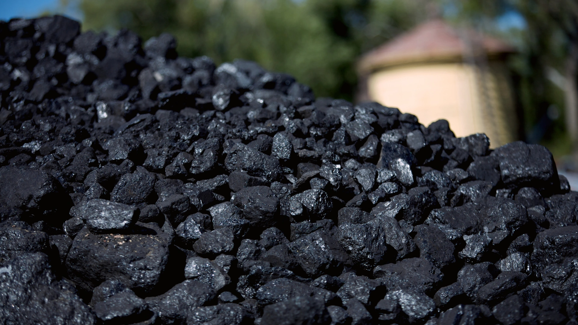 Wholesale coal sales — a large pile of shiny, irregular chunks of hard coal arranged outdoors, ready for loading and distribution.