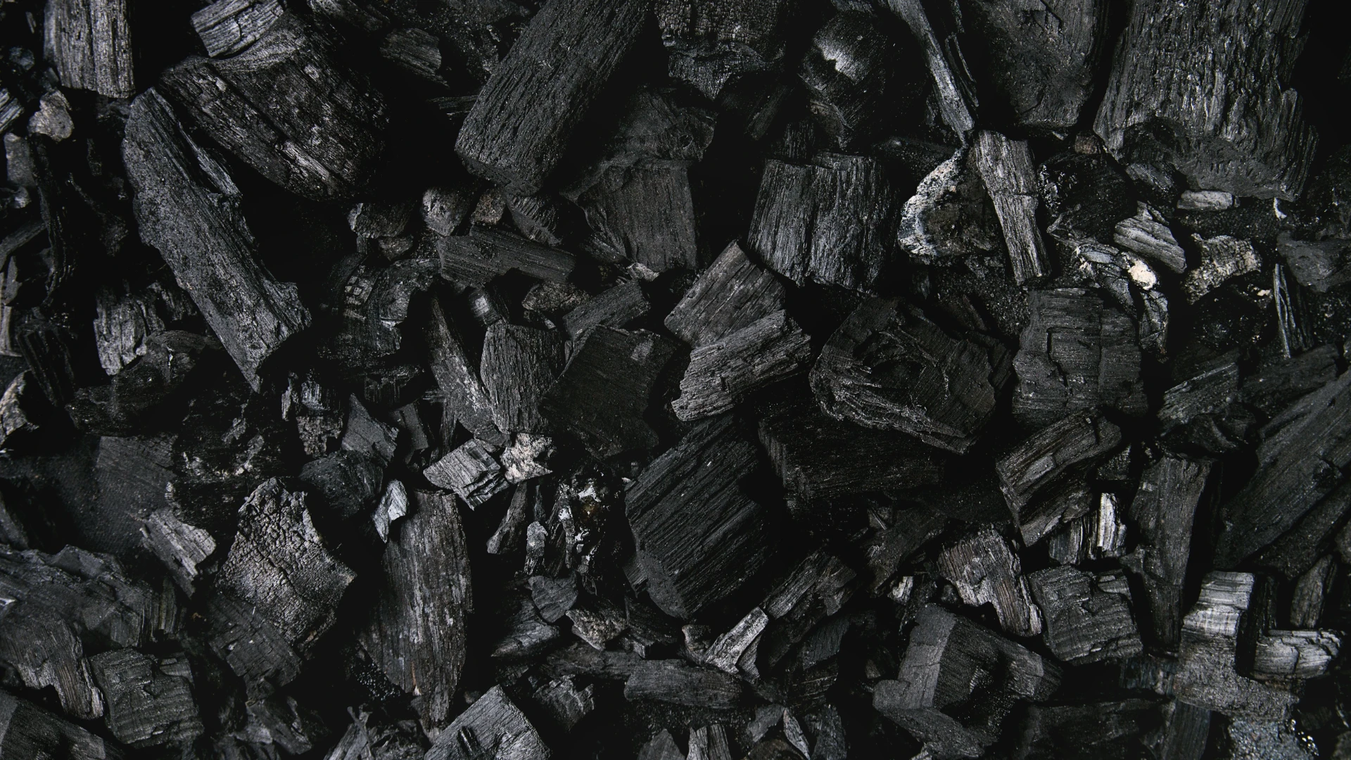 Online Coal Sales – shot of charcoal pieces in dark shades, symbolizing high-quality solid fuel.