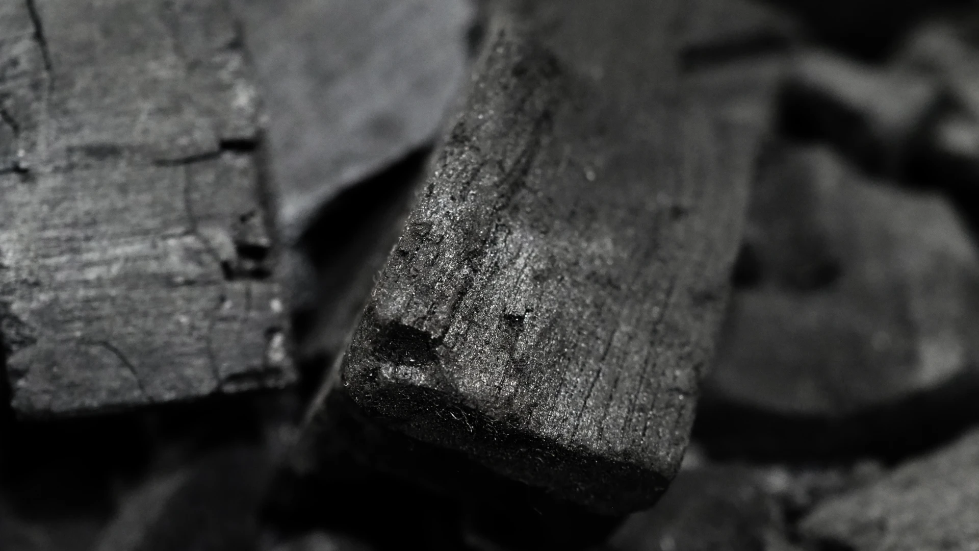 Holzkohle für die Industrie – Nahaufnahme kompakter Holzkohlestücke mit ausgeprägter Struktur für Industrie und Energie.