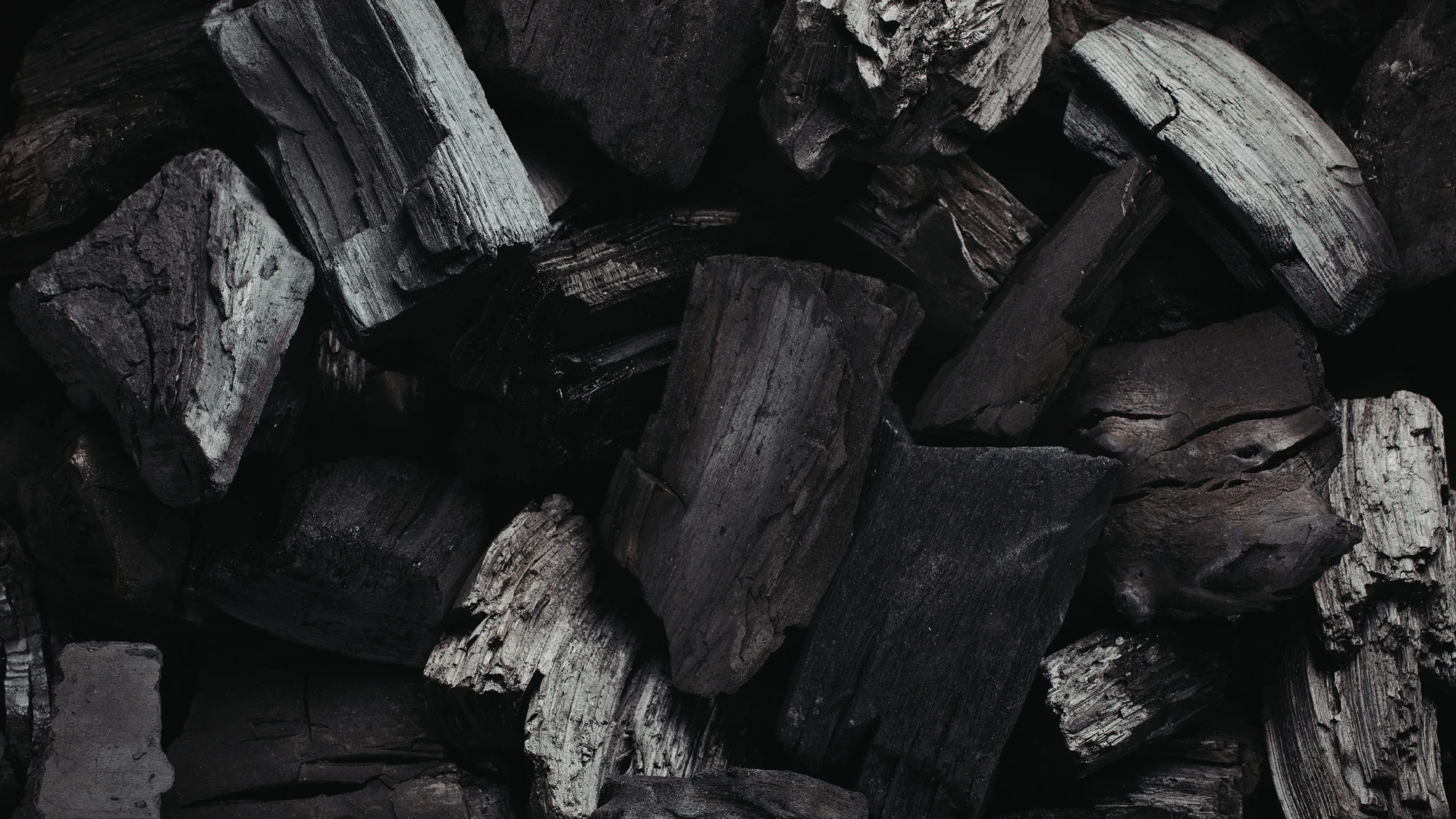 Holzkohle für die Industrie – Nahaufnahme massiver, unregelmäßiger Stücke mit sichtbarer Maserung und hoher Dichte für Industrie und Energie.