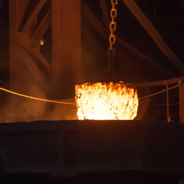 Ferroalloys in liquid form – a glowing ladle filled with molten iron alloy and elemental additives during the casting process in a steel plant.